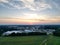 the sun setting over a large farm with buildings in it