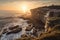 the sun setting over a picturesque coastal cliff, with the rocks and ocean in the background