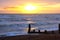 Sun setting over a sea with waves breaking and a wooden sea break, Brighton, Uk