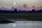 Sun Setting On Teton Mountain Range Tetons with River Flowing and Moon