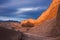 The sun is setting wonderfully on rocky cliffs in moon valley in the atacama desert while overcast by a stormy sky