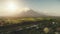 Sun shine over Mayon volcano erupts aerial. River at green grass hillside. Tropic forest at Legazpi