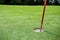 Sun shines behind a golf flag