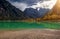 The sun shines through big majestic mountains view of the dolomites Cristallo group Lake Landro Italy