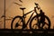 The sun shines through the frame of a bicycle with silhouette of bicycle rider