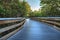 Sun shines through mangrove trees that line a Boardwalk leading down to the beach of Clam Pass