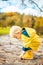 Sun always shines after the rain. Small bond infant boy wearing yellow rubber boots and yellow waterproof raincoat