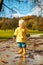 Sun always shines after the rain. Small bond infant boy wearing yellow rubber boots and yellow waterproof raincoat