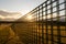 Sun shines through a snow guard fence