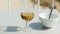 Sun shines to glass half full with beer, smaller porcelain coffee cup near, left on table by hotel guests, blurred beach in