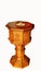 Sun shining on antique wooden baptismal font with white background