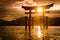 Sun shining through the Miyajima torii gate with mountains in the background during a stunning sunset. The large Japanese torii