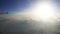 Sun shining over snow-capped mountains, view from flying airplane, high altitude