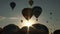 Sun shining and silhouette of balloon going into the sky