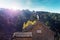 Sun shinning over a watch tower of the Mutianyu section of the Great Wall of China, surrounded by vegetation under a