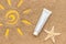 Sun sign drawn on sand, starfish and white tube of sunscreen, closeup. Template mockup for your design. Creative top