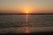 Sun sinks into the sea on the beach of Katwijk with colorful sky