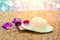 Sun straw hat, flip flop sandals, and sunglasses lying on the beach