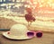 Sun straw hat and sunglasses lying on the bamboo mat at the beach