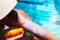 Sun text on sunscreen applied with spray on woman arm at poolside