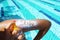 Sun text on sunscreen applied with spray on woman arm at poolside