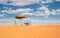 Sun umbrella and chairs in desert