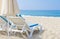 Sun umbrella and chaise longue on sea beach. White sand and sea in tropical resort