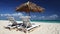 Sun umbrellas and beach chairs on tropical beach. Travel destination