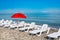 Sunbathing plastic beds and red umbrella on the beach