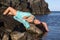Sunbathing woman on beach rock