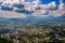 Sunbeam passing through the cloud over Chiangrai city with green grass field and mountain range. the areal shot has been taken thr