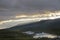 Sunbeams forming over mountains on sunset giving beautiful golden light over river in Sarek, Sweden