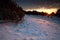 Sunbeams over snowy hills at sunset