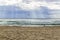 Sunbeams on the sandy beach with seagulls as protagonists, flying over the sea.