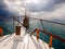 Sunbeams shines through the clouds, view from the bow of the yacht. Concept of summer vacation at sea for travel agencies