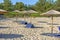 Sunbed, straw umbrella on beautiful beach background in Greece