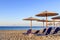 Sunbed, straw umbrella on beautiful rising sun beach background