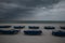 Sunbeds with blue towels on a sandy beach in stormy weather. gray thunder clouds