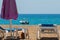 Sunbeds and large umbrella on rocky beach, near the ocean