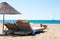 Sunbeds and rattan parasols on sandy seaside