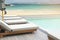 Sunbeds on Swimming Pool Wooden Deck with White Sand Beach and Blue Sea Background