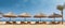 Sunbeds and umbrellas in a row on a tropical sunny beach, generative ai