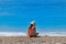 Sunburned young woman sitting at seashore