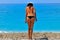 Sunburned young woman standing at seashore