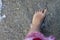 Sunburnt foot of a woman in shallow transparent ocean waters. Sand and shells.