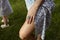 Sunburnt women legs in summer cloth and hand