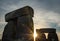 Sunburst between great stones at Stonehenge, u.k. on summer solstic