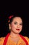 Sundanese woman wearing a short dress and traditional yellow dress with red scarf and makeup after the dance performance