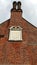 Sundial on red brick building