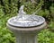 Sundial with a sculpture of a small flying bird in a garden at the Hill and Gilstrap Law Firm in Arlington, Texas.